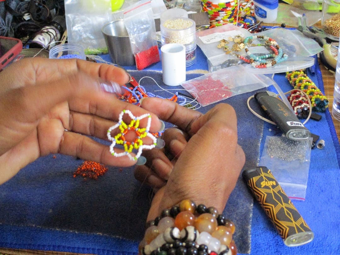 A craftswoman making beaded jewellery at an arts centre in Gaborone
